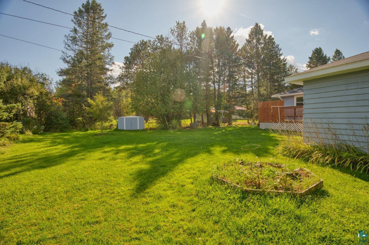 5316 Highway 110 Aurora, MN 55705 - Photo 26 of 35 View of green lawn featuring a storage unit and a deck