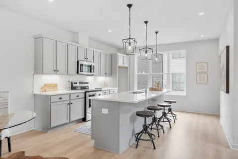 a kitchen with stainless steel appliances granite countertop white cabinets and window