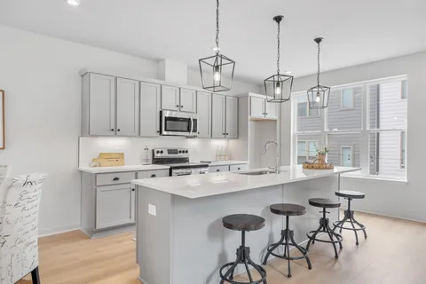 a kitchen that has a lot of cabinets in it and wooden floors