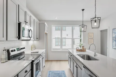 a kitchen with stainless steel appliances white cabinets and a stove top oven
