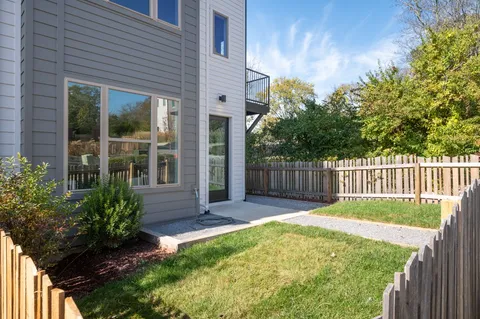 a view of a house with a small yard and flower plants