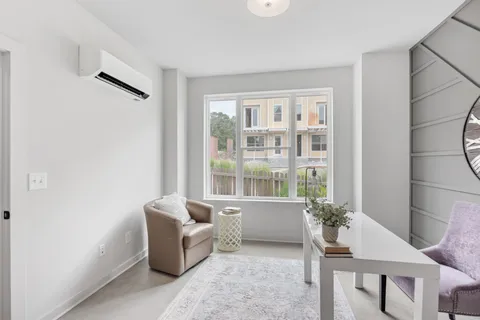 a living room with couches and a dining table with wooden floor