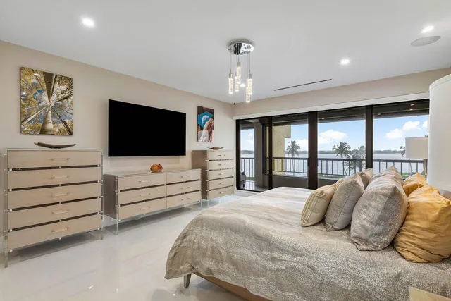 a spacious bedroom with a bed and a flat screen television