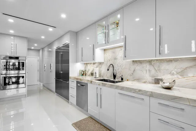 a kitchen with a sink white cabinets and stainless steel appliances
