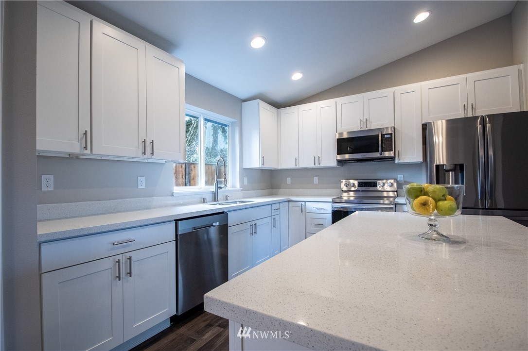 5031 East Rasor Road Belfair, WA 98528 - Photo 2 of 16 a kitchen with a sink a microwave a refrigerator and cabinets