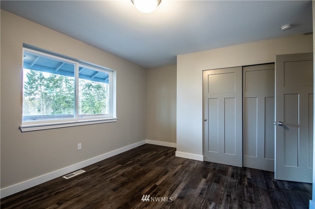 5031 East Rasor Road Belfair, WA 98528 - Photo 12 of 16 a view of an empty room with wooden floor and a window