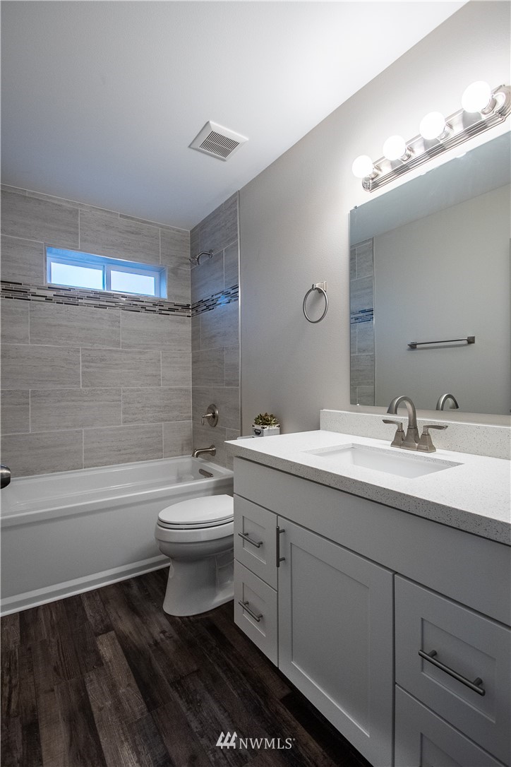 5031 East Rasor Road Belfair, WA 98528 - Photo 13 of 16 a bathroom with a double vanity sink toilet mirror and bathtub