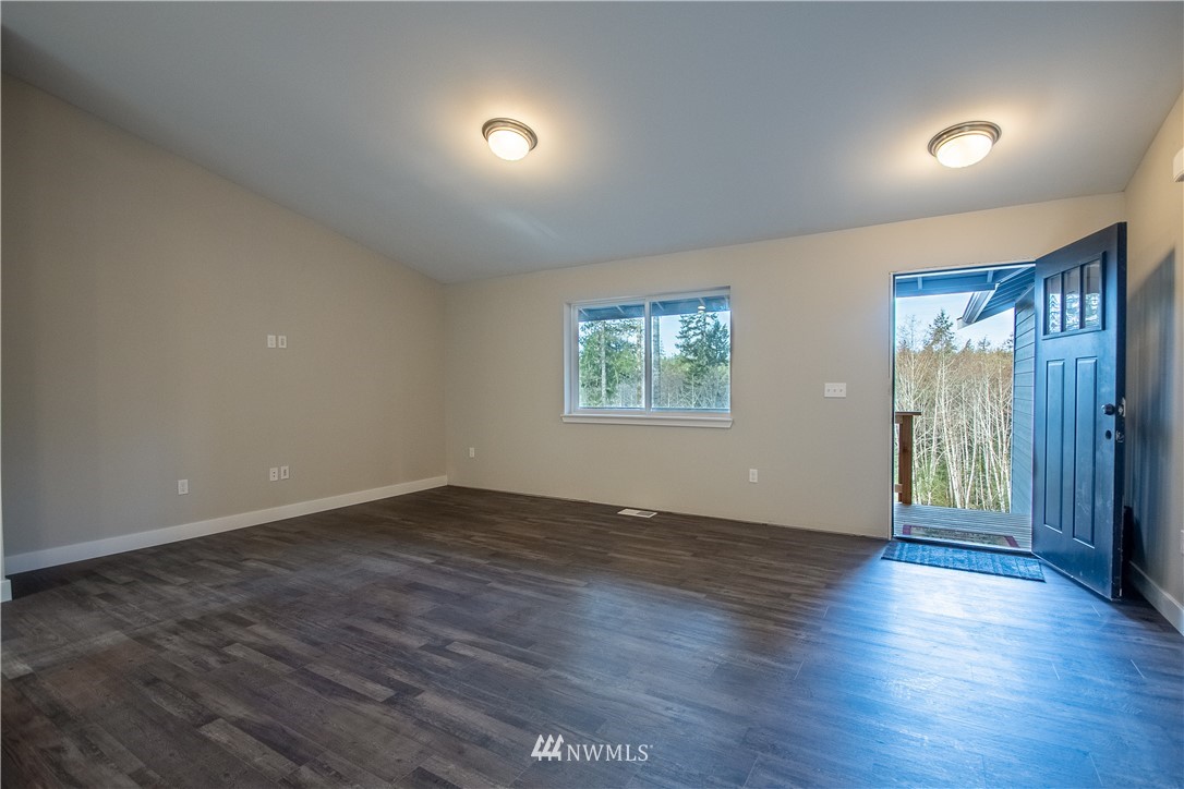 5031 East Rasor Road Belfair, WA 98528 - Photo 7 of 16 an empty room with wooden floor and windows