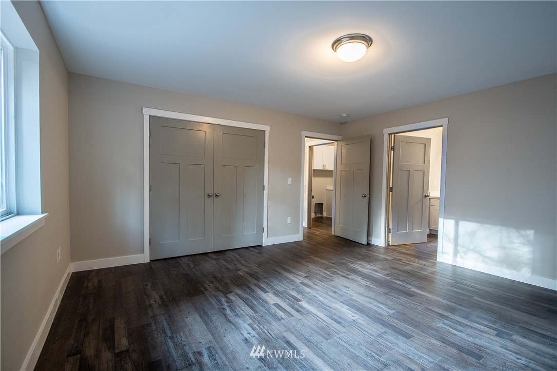 5031 East Rasor Road Belfair, WA 98528 - Photo 8 of 16 an empty room with wooden floor and windows