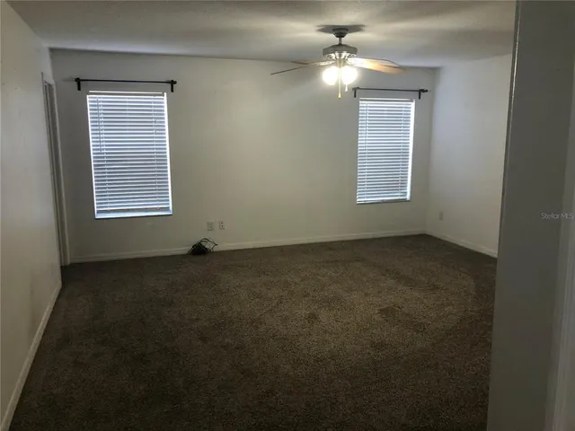 a view of a livingroom with a ceiling fan and window
