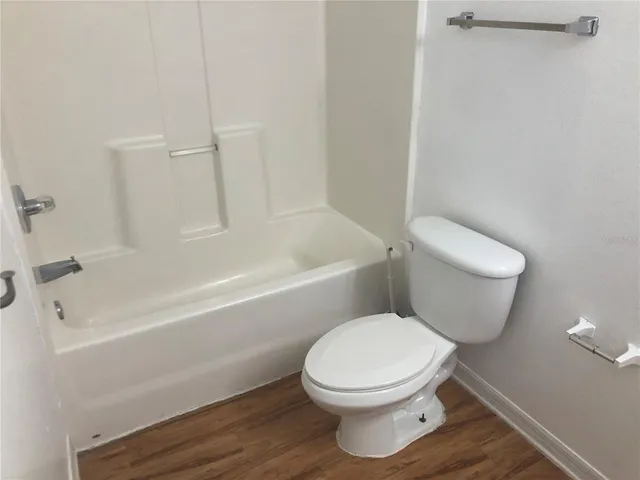 a white toilet and tub sitting next to a bathroom sink