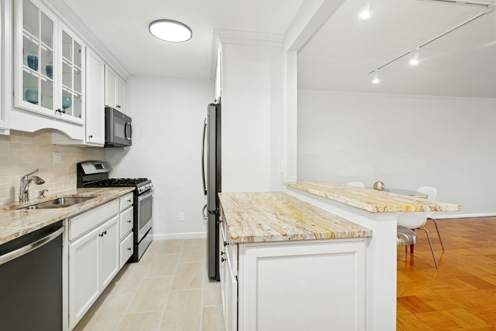 6 Whittier Place, Unit 9H Boston, MA 02114 - Photo 6 of 26 a kitchen with a sink appliances and cabinets