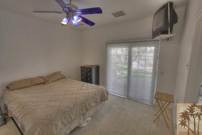 43094 Joshua Road Rancho Mirage, CA 92270 - Photo 19 of 25 a bedroom with a bed and a chandelier