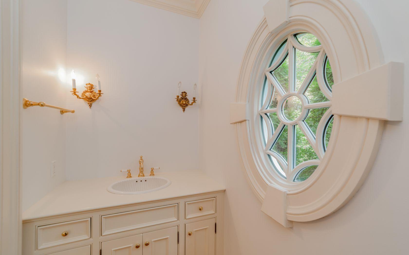 1601 Ponus Ridge Road New Canaan, CT 06840 - Photo 36 of 88 a bathroom with a sink a mirror and a window