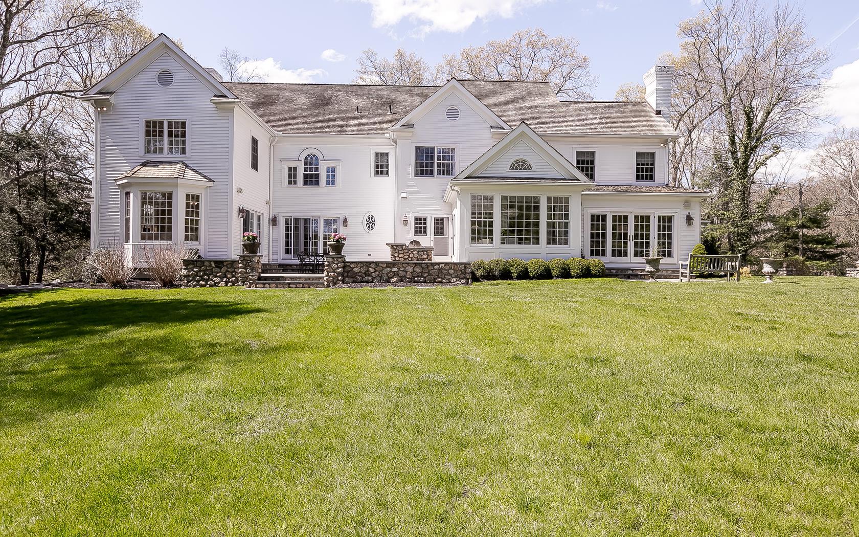 1601 Ponus Ridge Road New Canaan, CT 06840 - Photo 5 of 88 a view of a white house with a big yard and large trees