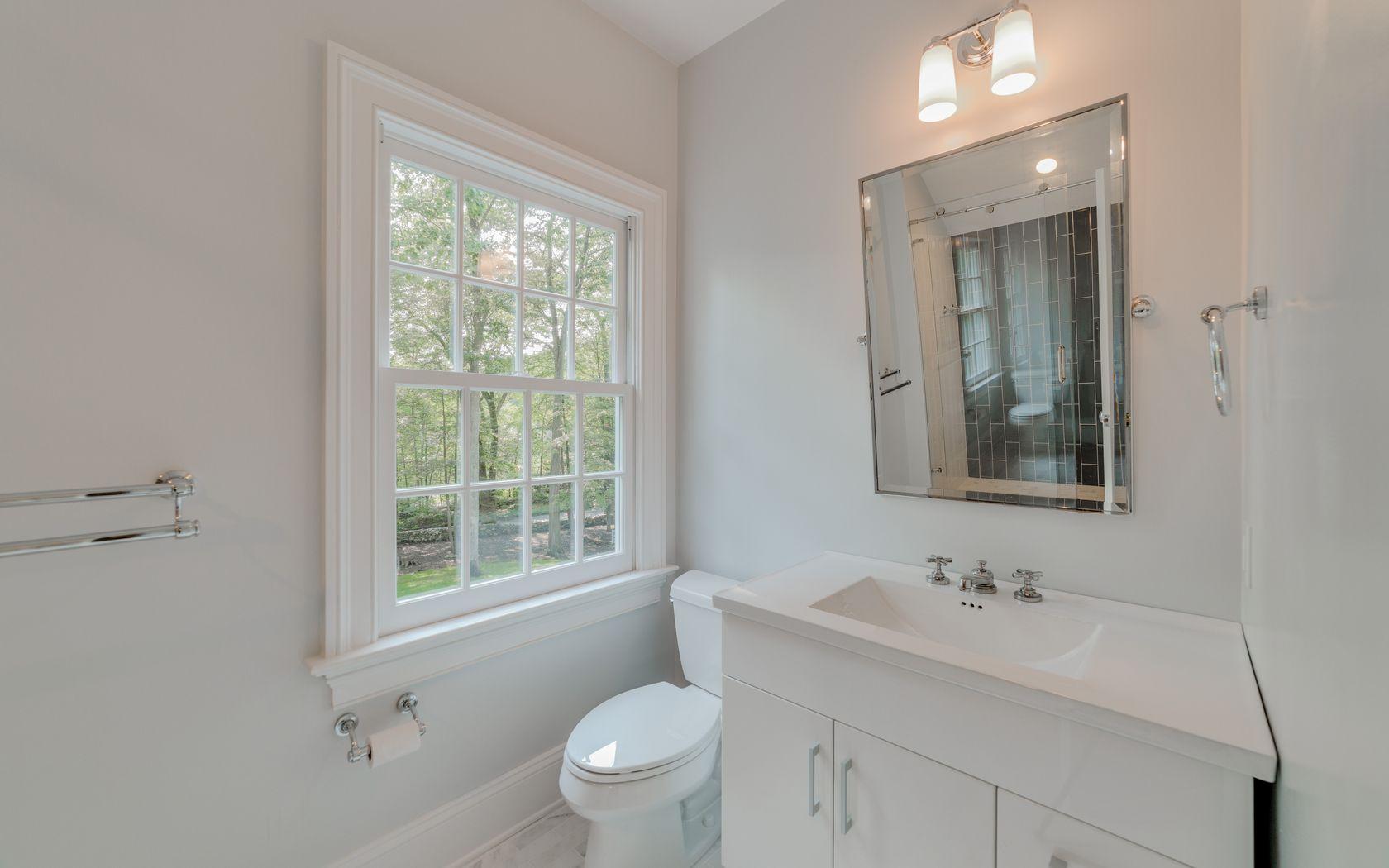 1601 Ponus Ridge Road New Canaan, CT 06840 - Photo 60 of 88 a bathroom with a toilet a sink a mirror a window and vanity