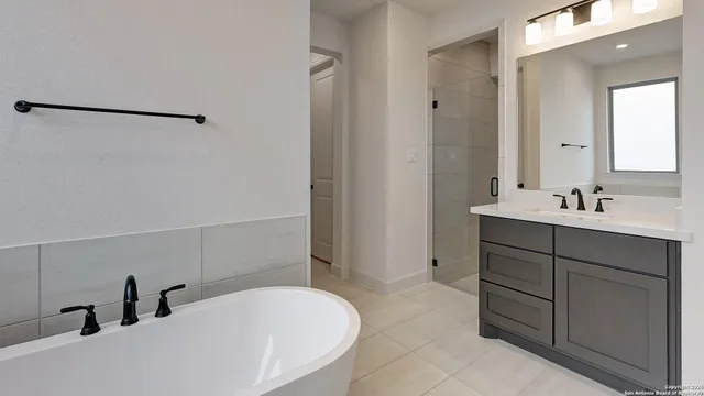 a bathroom with a tub sink and mirror