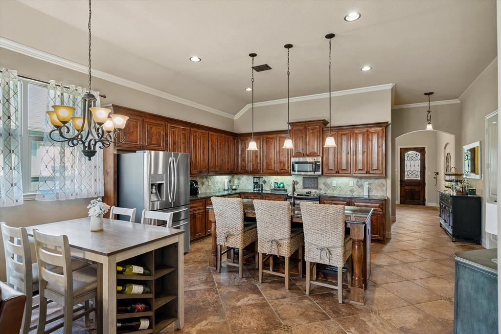 1007 Somerset Circle Forney, TX 75126 - Photo 12 of 34 a kitchen with a dining table chairs and white cabinets