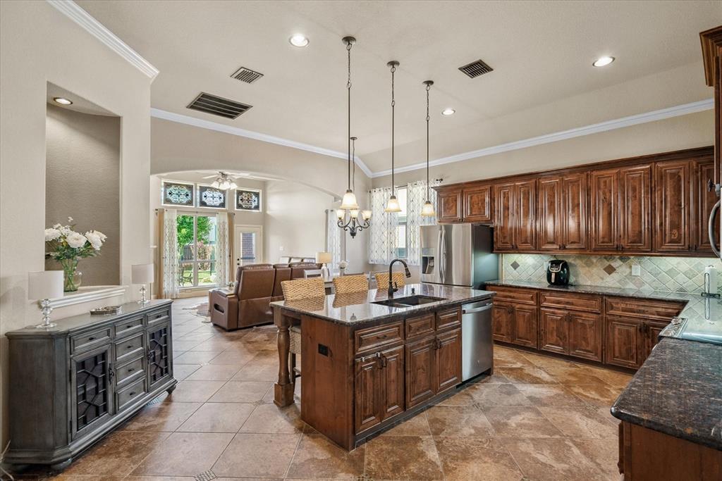 1007 Somerset Circle Forney, TX 75126 - Photo 23 of 34 a kitchen with stainless steel appliances granite countertop a stove a sink and a refrigerator