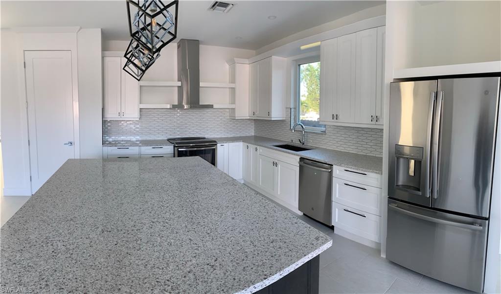 799 104th Avenue North Naples, FL 34108 - Photo 11 of 22 a kitchen with stainless steel appliances granite countertop a sink stove and refrigerator