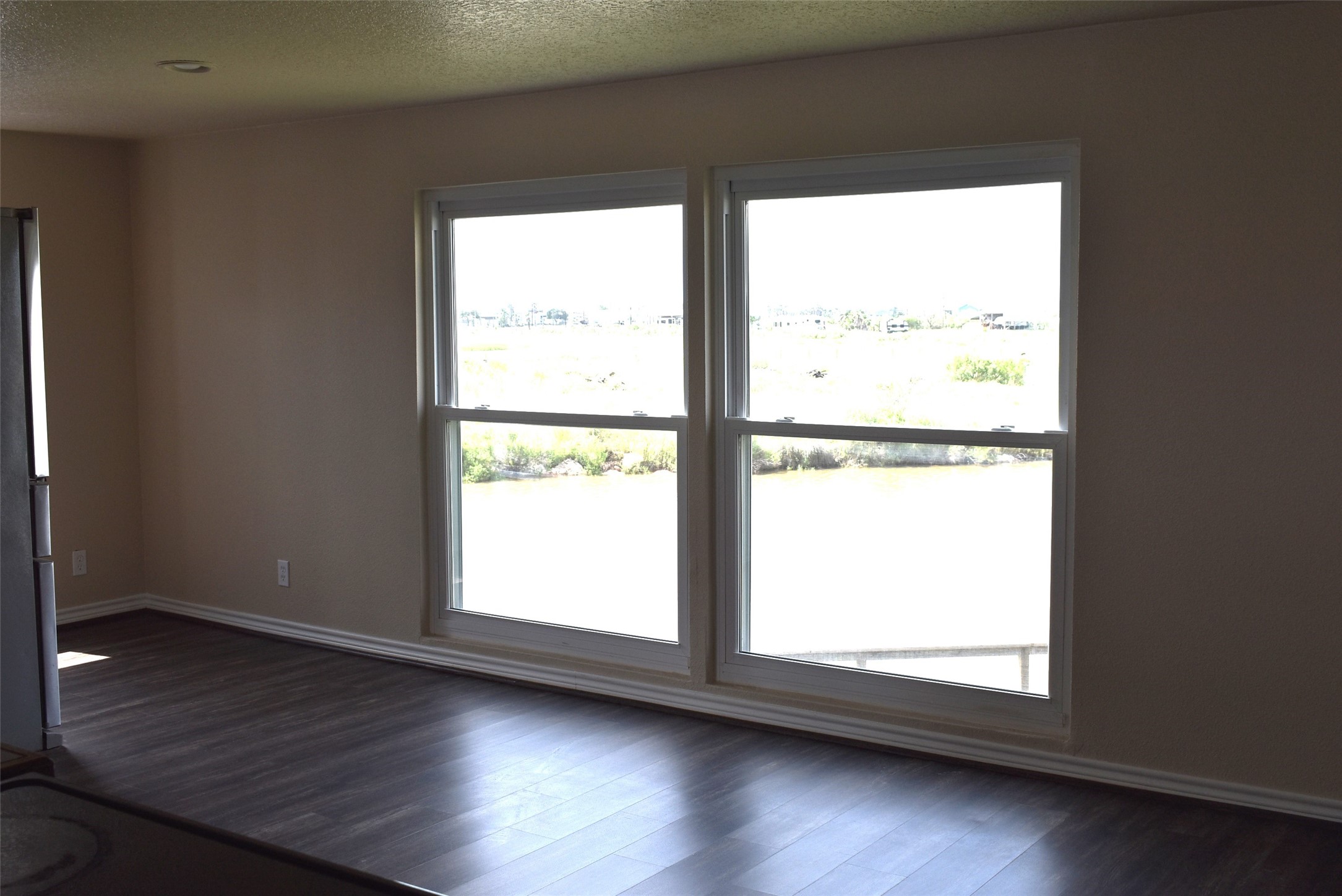 11 Chimaera Street Sargent, TX 77414 - Photo 20 of 40 a view of an empty room with wooden floor and a window