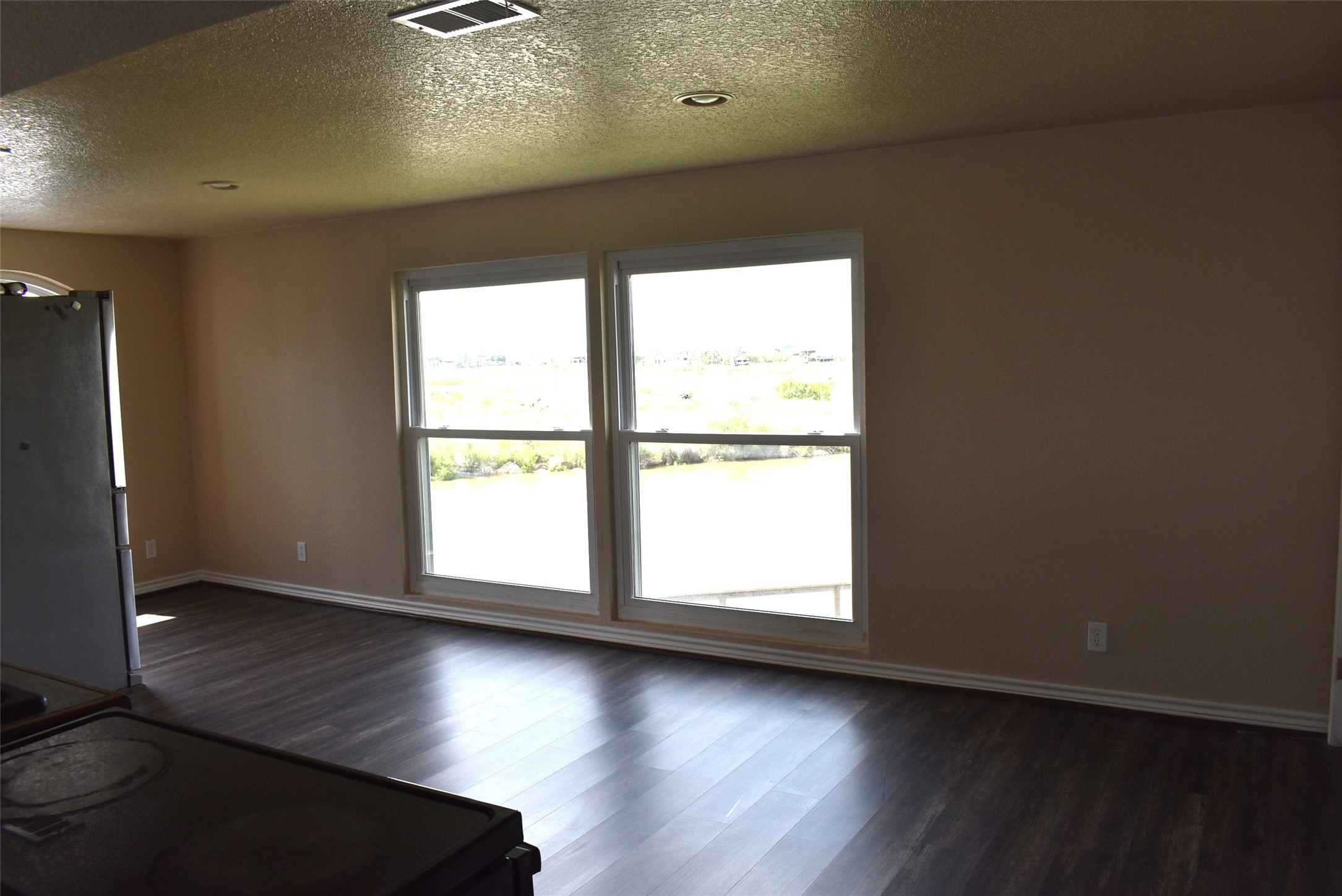 11 Chimaera Street Sargent, TX 77414 - Photo 21 of 40 an empty room with wooden floor and windows