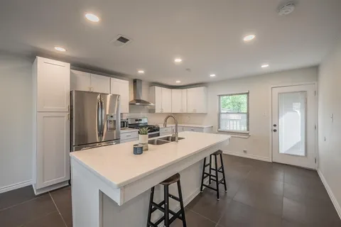 a kitchen with a sink a refrigerator and wooden cabinets