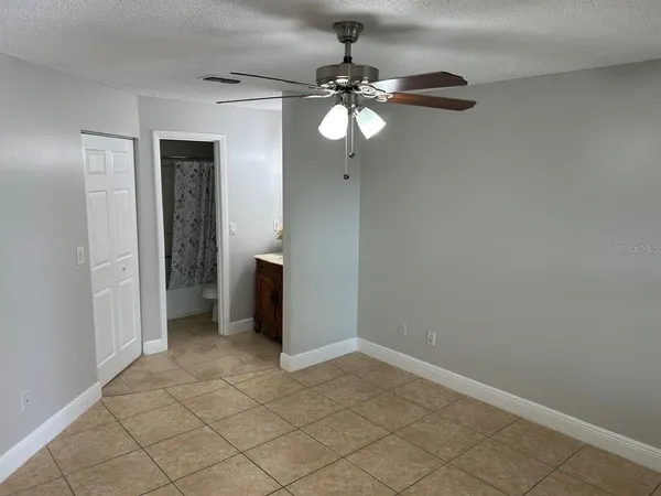 an empty room with chandelier fan