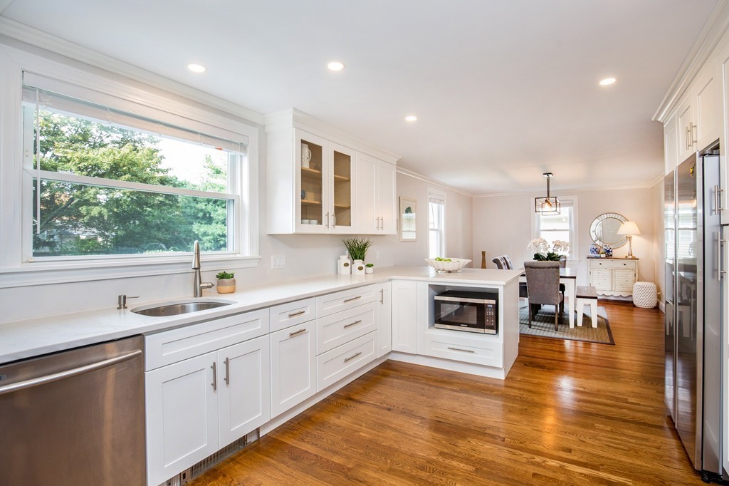 31 Ralph Road Marblehead, MA 01945 - Photo 7 of 24 a kitchen with stainless steel appliances granite countertop a stove top oven a sink dishwasher a refrigerator and white cabinets with wooden floor
