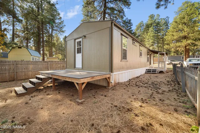 a backyard of a house with wooden fence and trees