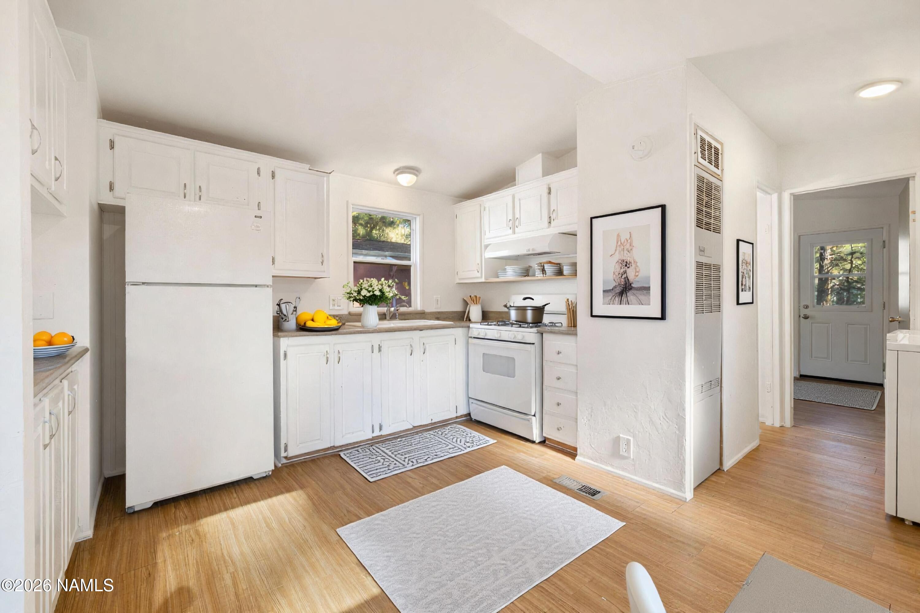 2500 West Rte 66, Unit 24 Flagstaff, AZ 86001 - Photo 3 of 13 a kitchen with white cabinets and white appliances