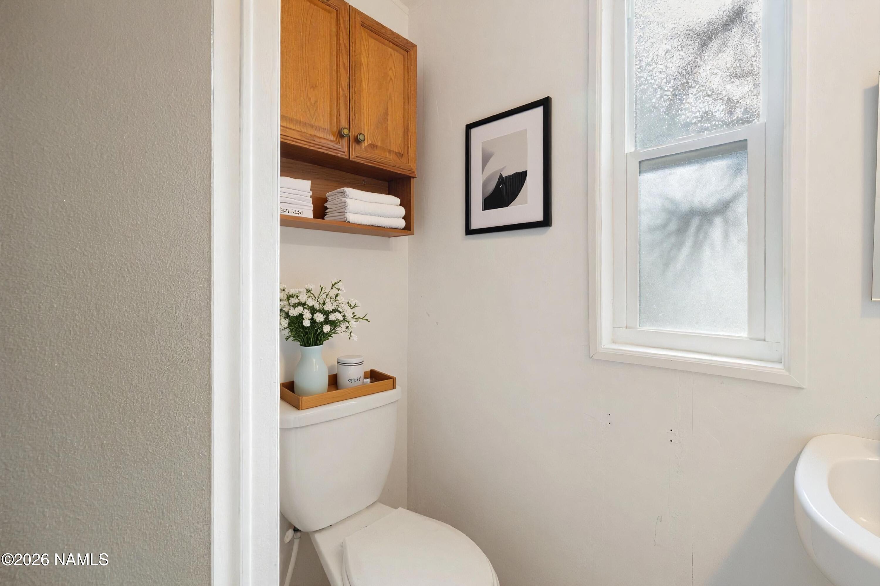 2500 West Rte 66, Unit 24 Flagstaff, AZ 86001 - Photo 5 of 13 a white toilet sitting next to a bathroom sink and vanity