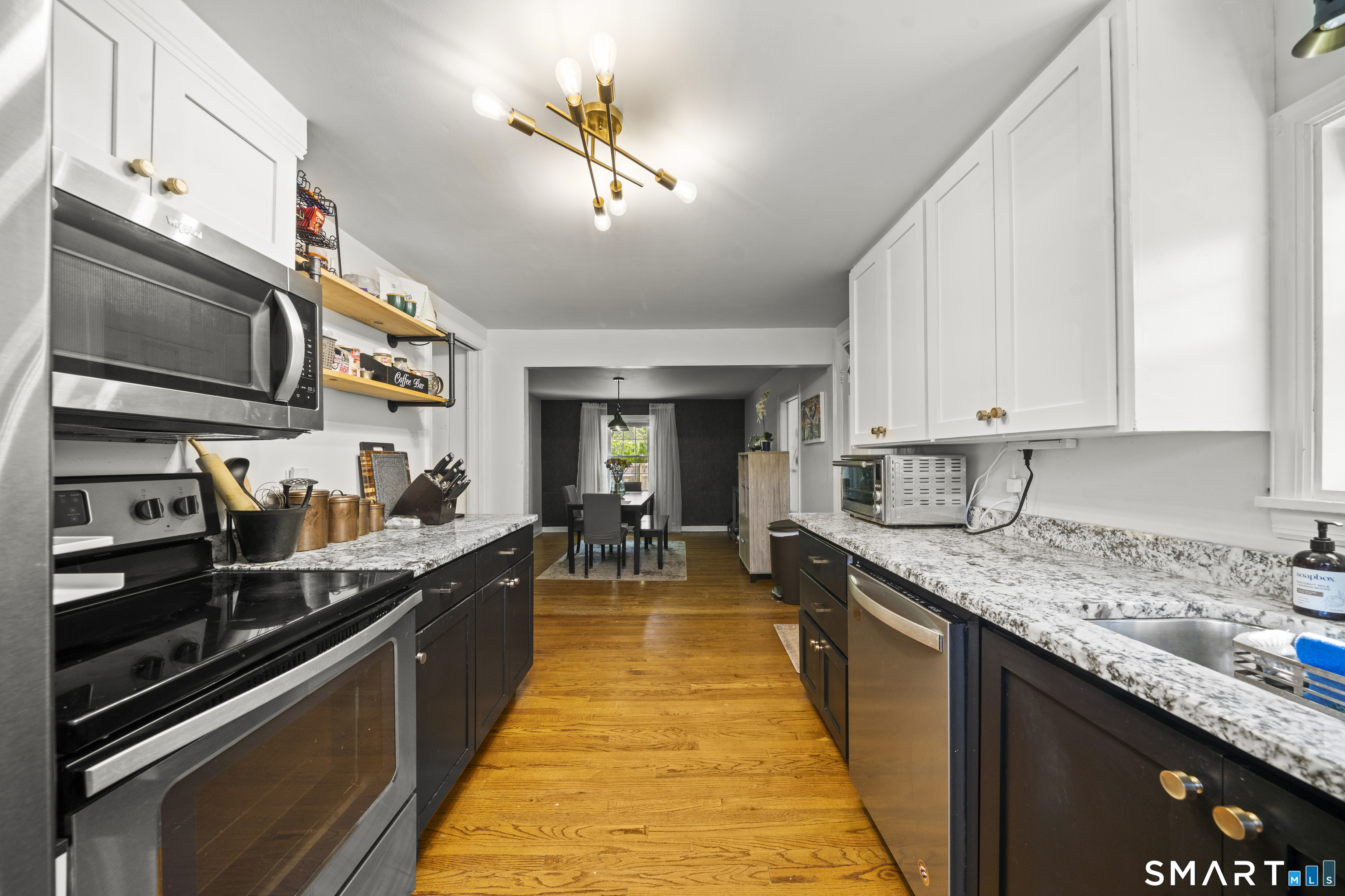 211 Whisconier Road Brookfield, CT 06804 - Photo 4 of 38 a large kitchen with stainless steel appliances granite countertop a sink dishwasher a stove top oven a dining table and chairs with wooden floor