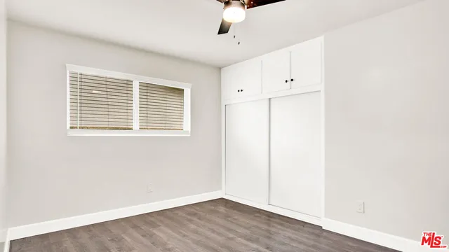 a backyard of a house with potted plants and large tree