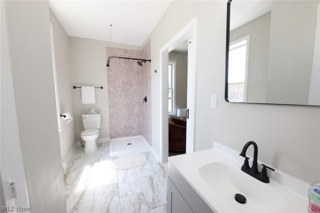 416 5th Street Chester, WV 26034 - Photo 13 of 24 Contemporary bathroom featuring a modern vanity with integrated sink, matte black faucet, and a large rectangular mirror