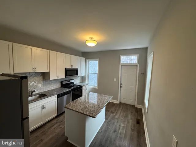 a kitchen with granite countertop a sink and steel appliances