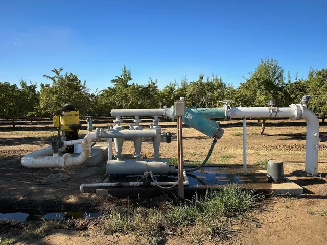a view of a swimming pool with lawn chairs under an umbrella