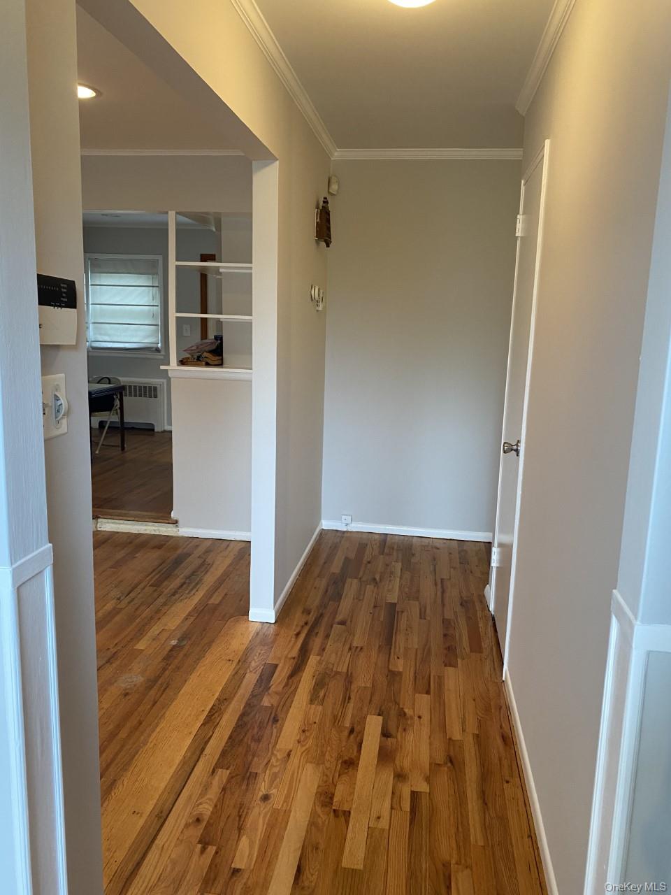 3 Wensley Road Plainview, NY 11803 - Photo 2 of 16 Hall with hardwood finished floors, crown molding, and radiator heating unit