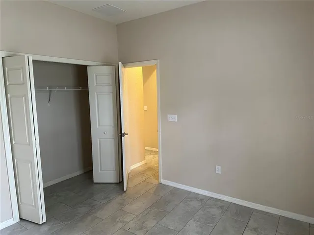 an empty room with closet and a window