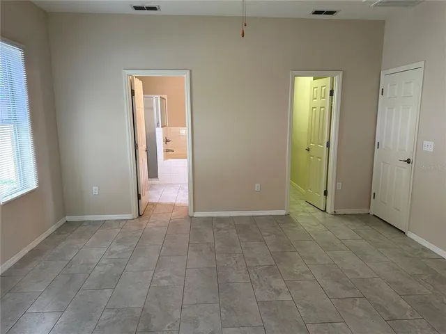 an empty room with closet and a window