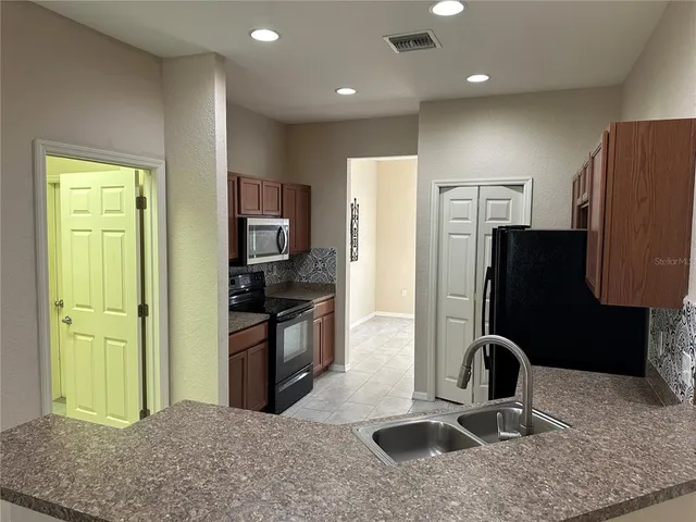 a kitchen with stainless steel appliances granite countertop a refrigerator and a sink