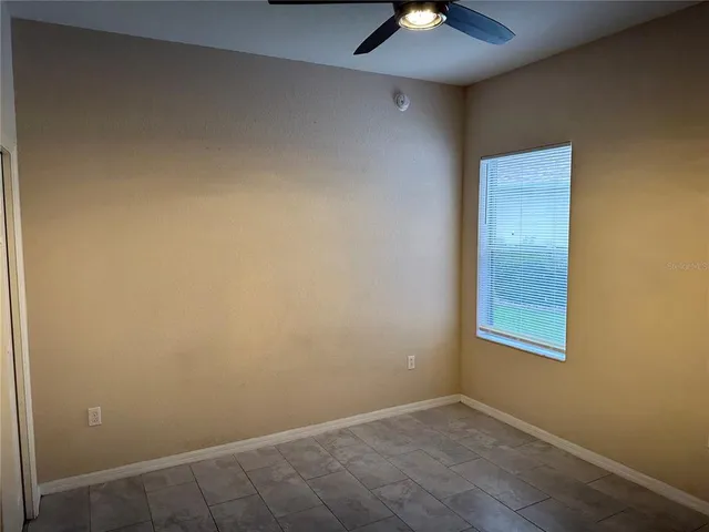 an empty room with a chandelier fan