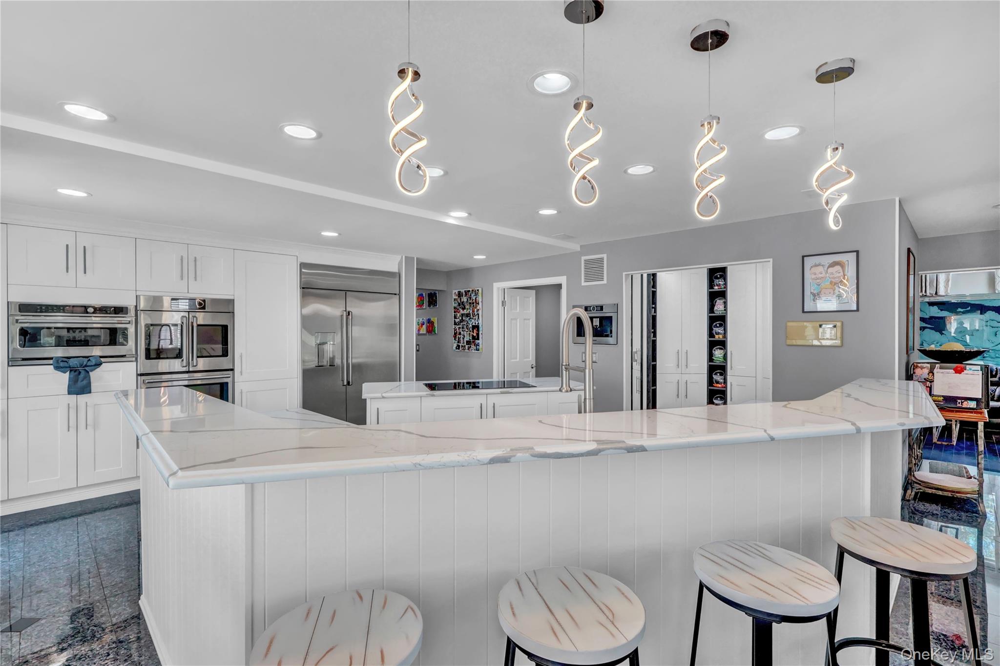 83 Cliff Road Port Jefferson, NY 11777 - Photo 11 of 50 Kitchen featuring appliances with stainless steel finishes, light stone counters, pendant lighting, recessed lighting, and white cabinetry