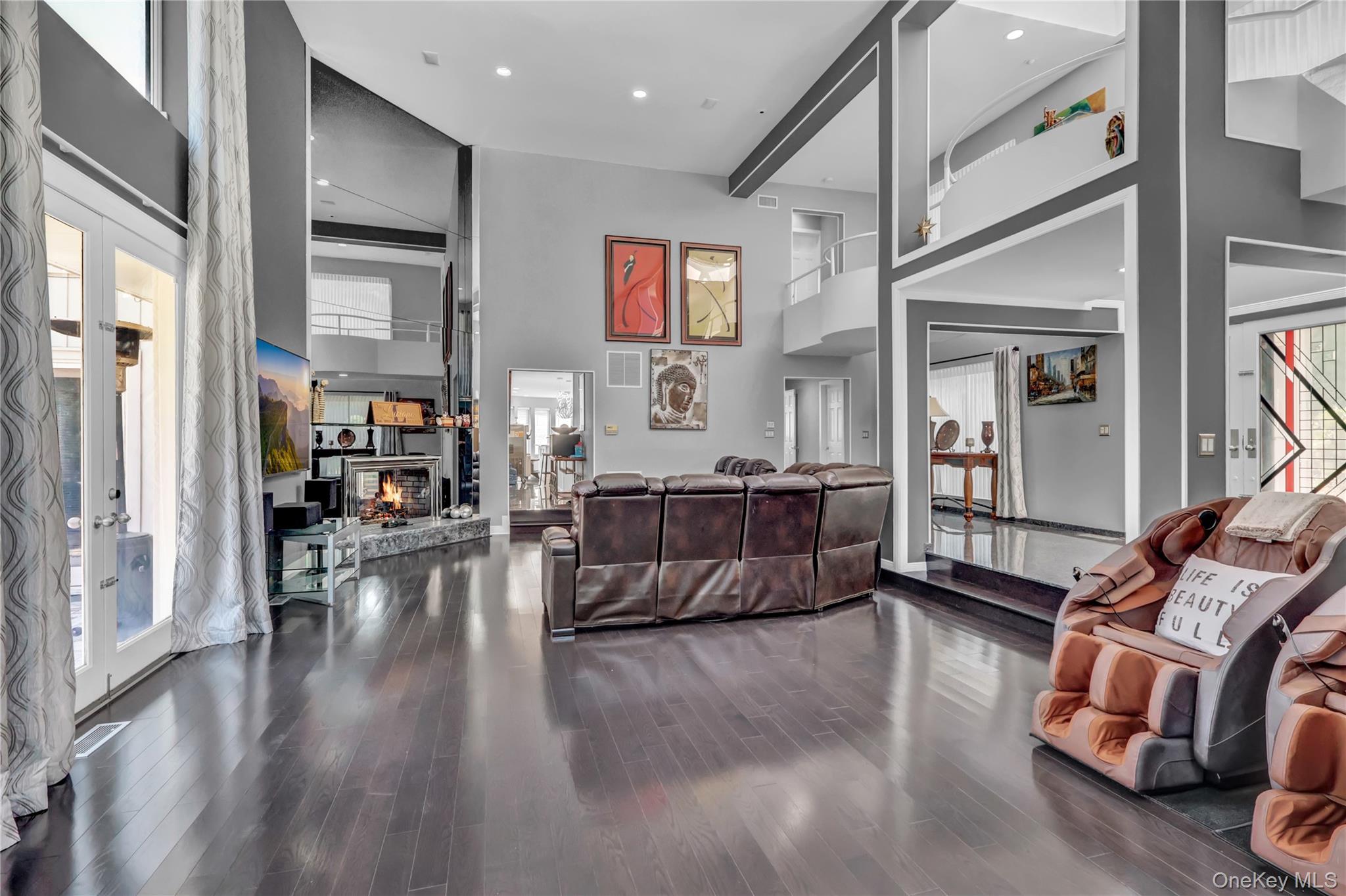 83 Cliff Road Port Jefferson, NY 11777 - Photo 17 of 50 Reception featuring a towering ceiling, a glass covered fireplace, and french doors