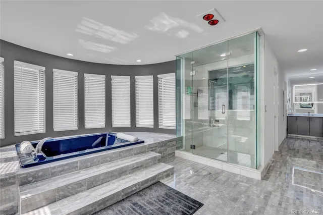 a spacious bathroom with a granite countertop tub shower and mirror