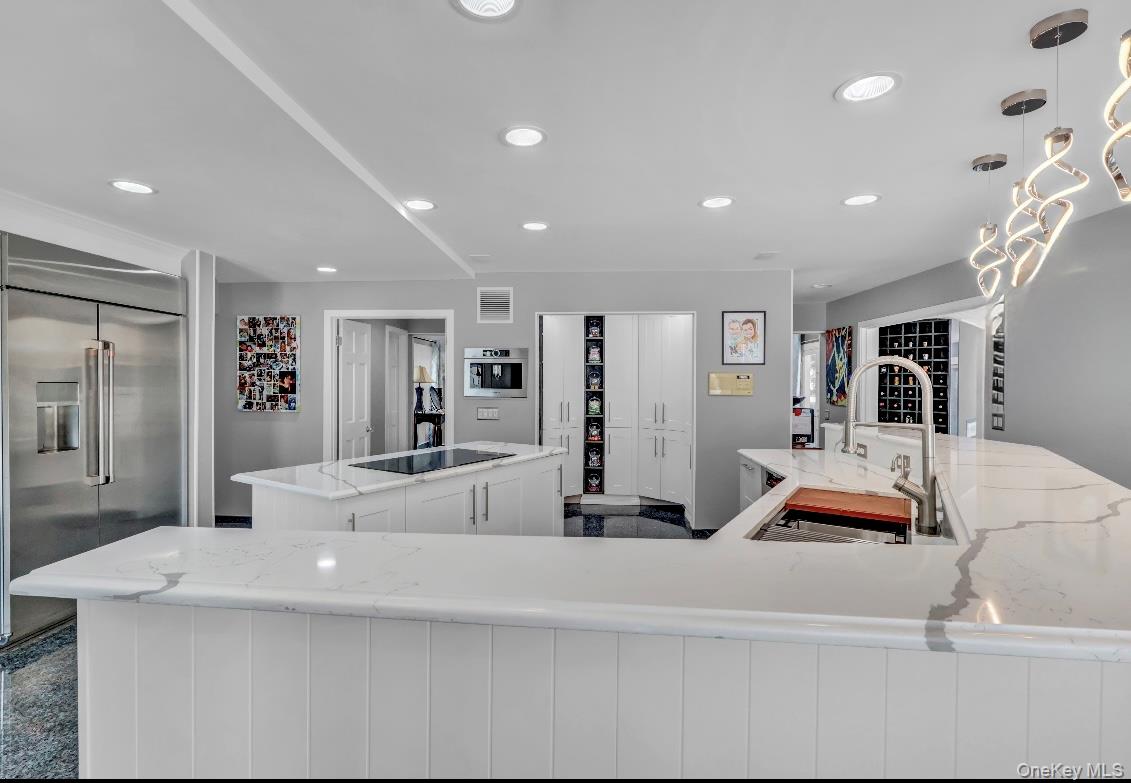 83 Cliff Road Port Jefferson, NY 11777 - Photo 10 of 50 Kitchen featuring stainless steel built in refrigerator, light stone counters, recessed lighting, and decorative light fixtures