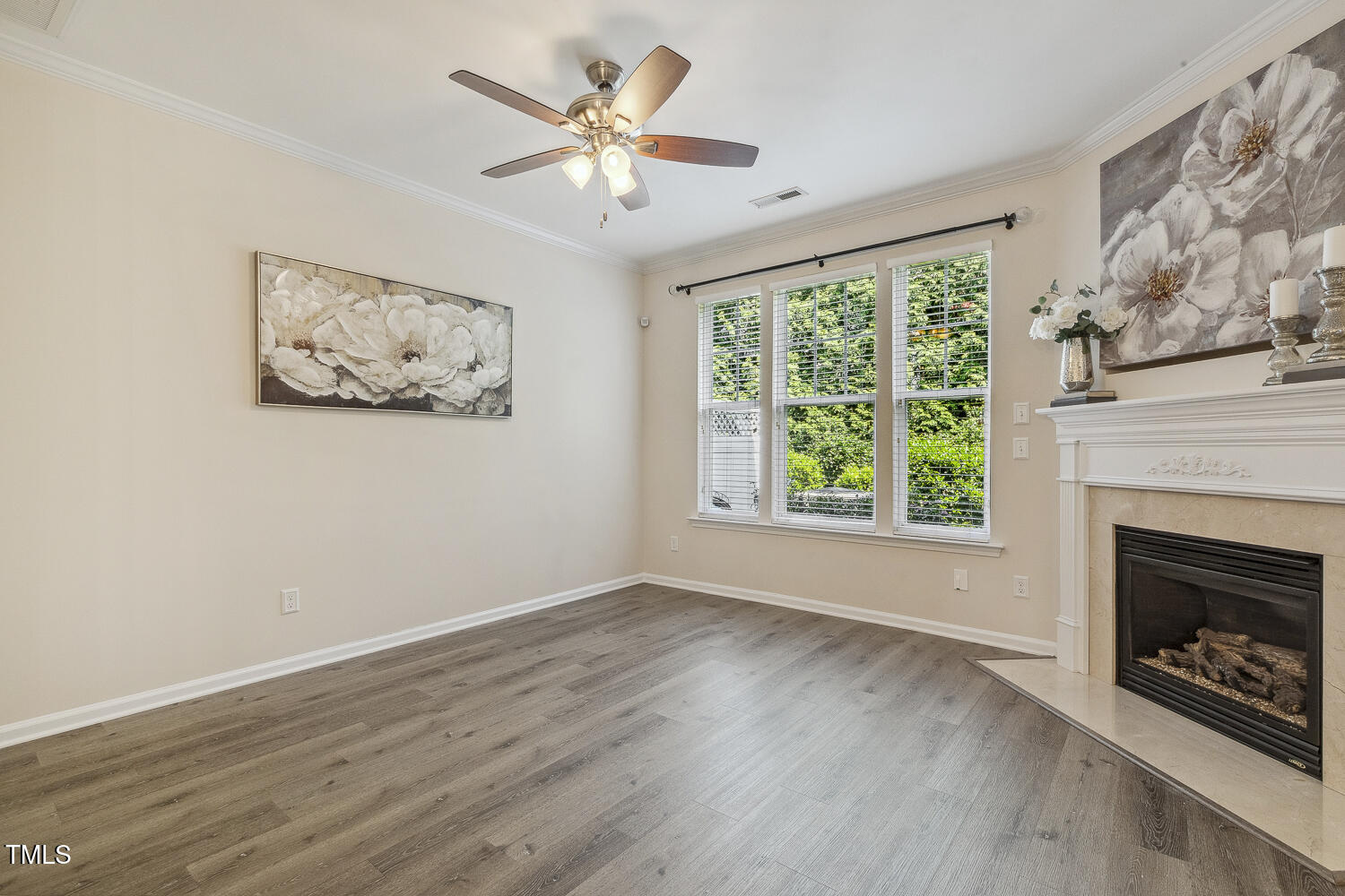 5936 Hourglass Court Raleigh, NC 27612 - Photo 5 of 15 a view of an empty room with wooden floor fireplace and a window