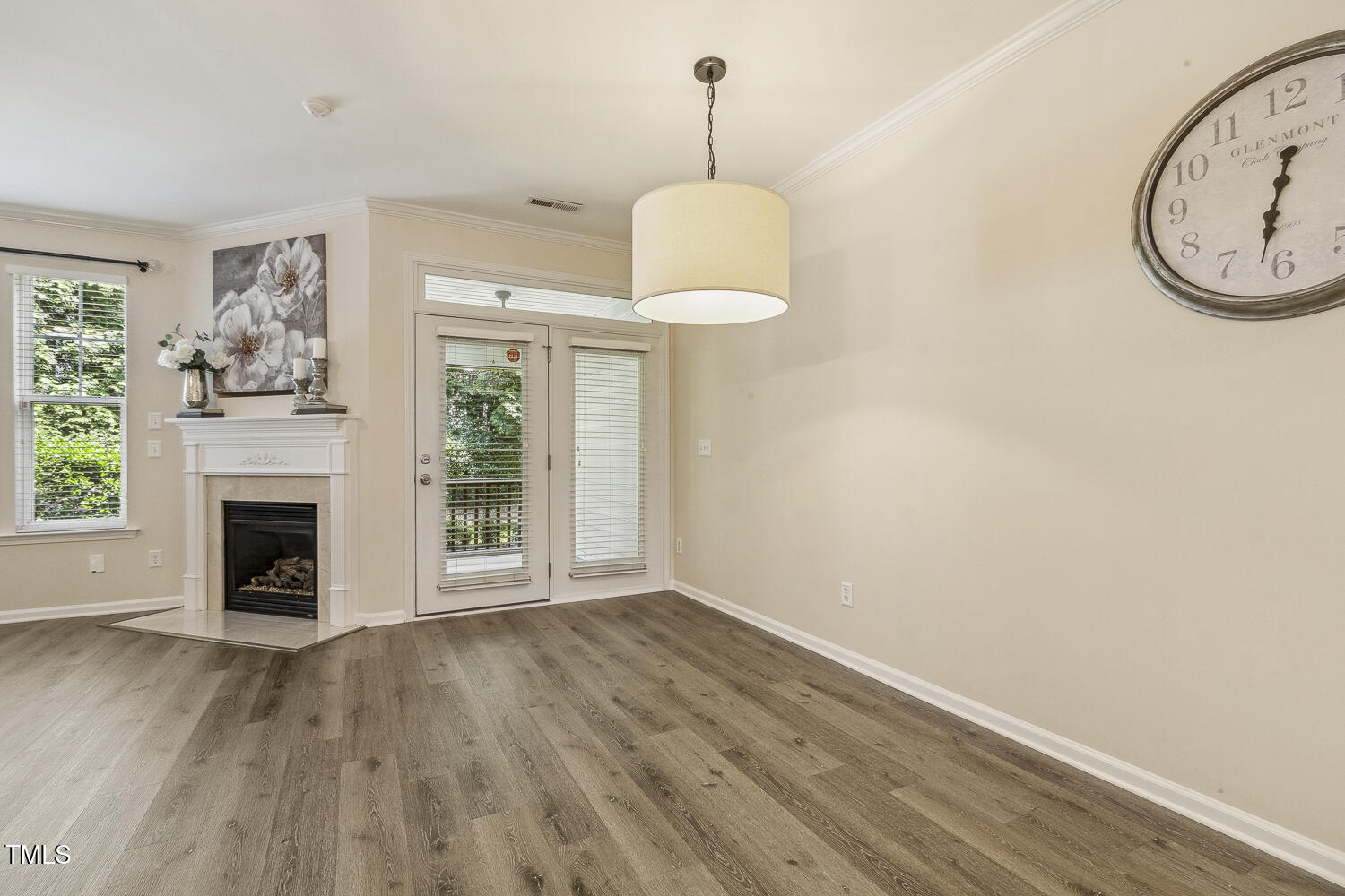 5936 Hourglass Court Raleigh, NC 27612 - Photo 7 of 15 a view of an empty room with wooden floor fireplace and a window