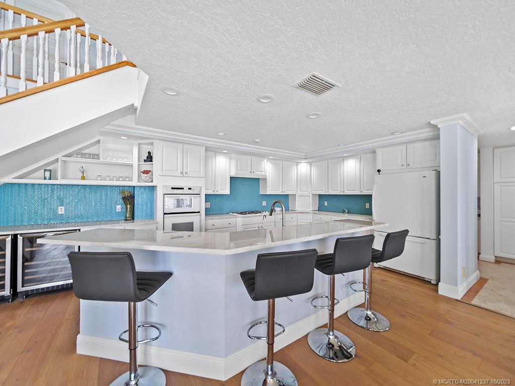 10 Island Road Stuart, FL 34996 - Photo 26 of 60 a kitchen with stainless steel appliances kitchen island a table and chairs in it