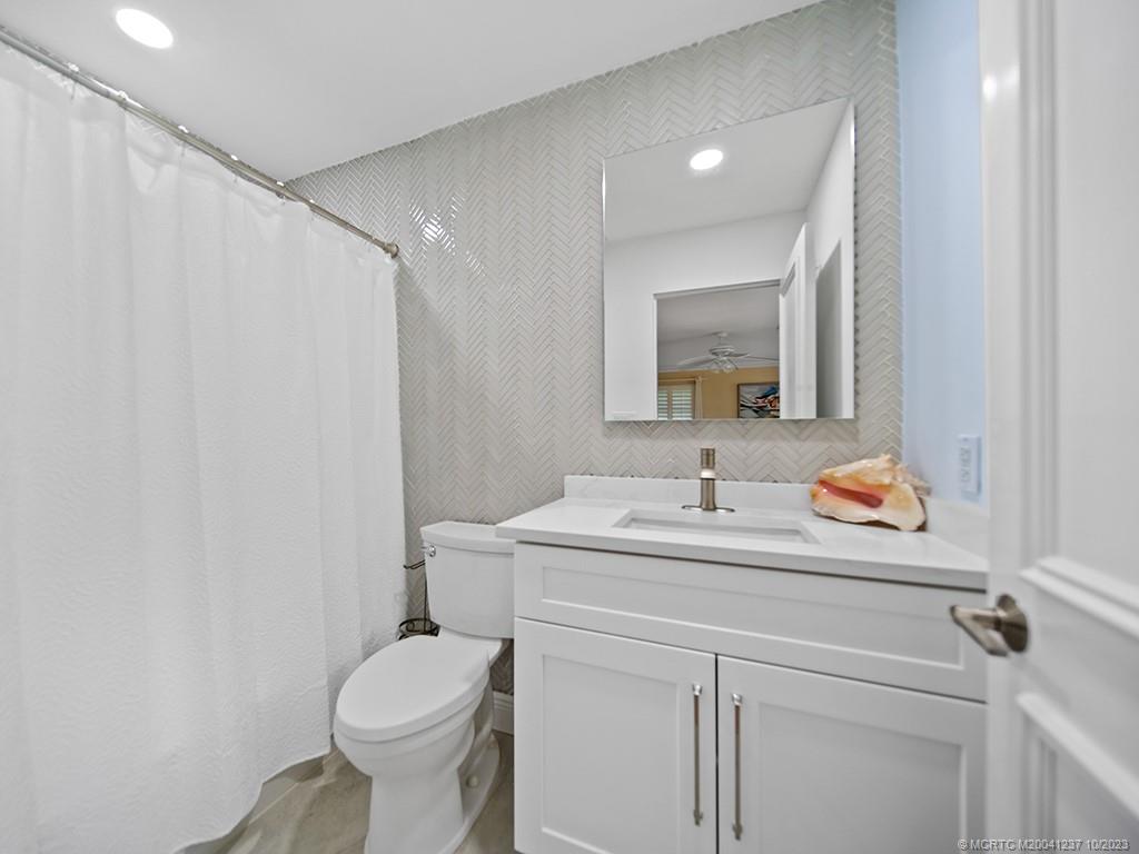 10 Island Road Stuart, FL 34996 - Photo 47 of 60 a bathroom with a toilet sink and mirror
